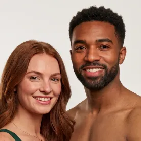 Casal sorrindo com destaque para os rostos e a pele.